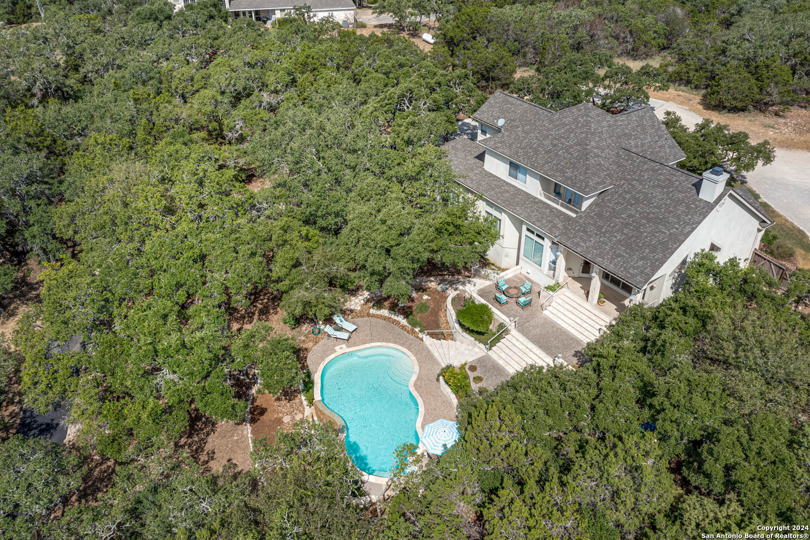 an aerial view of a house with a swimming pool and garden