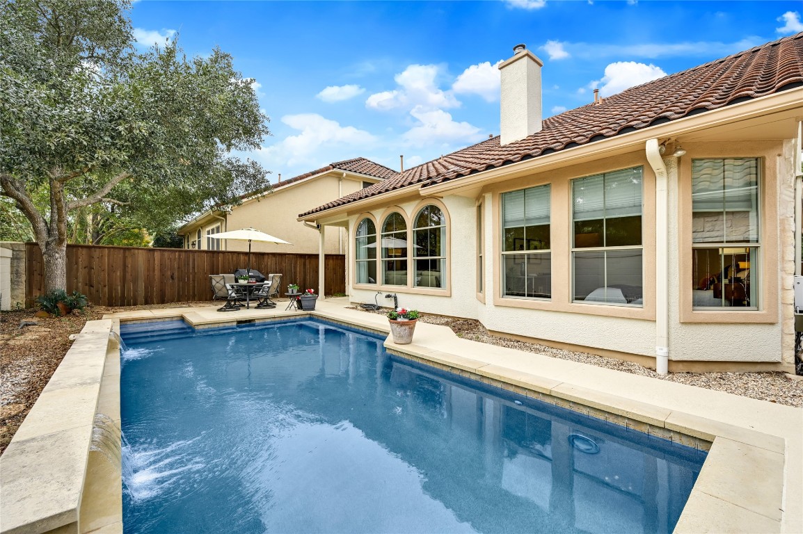 a view of a house with swimming pool and sitting area