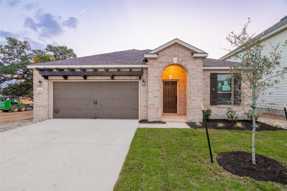 a front view of a house with yard and green space