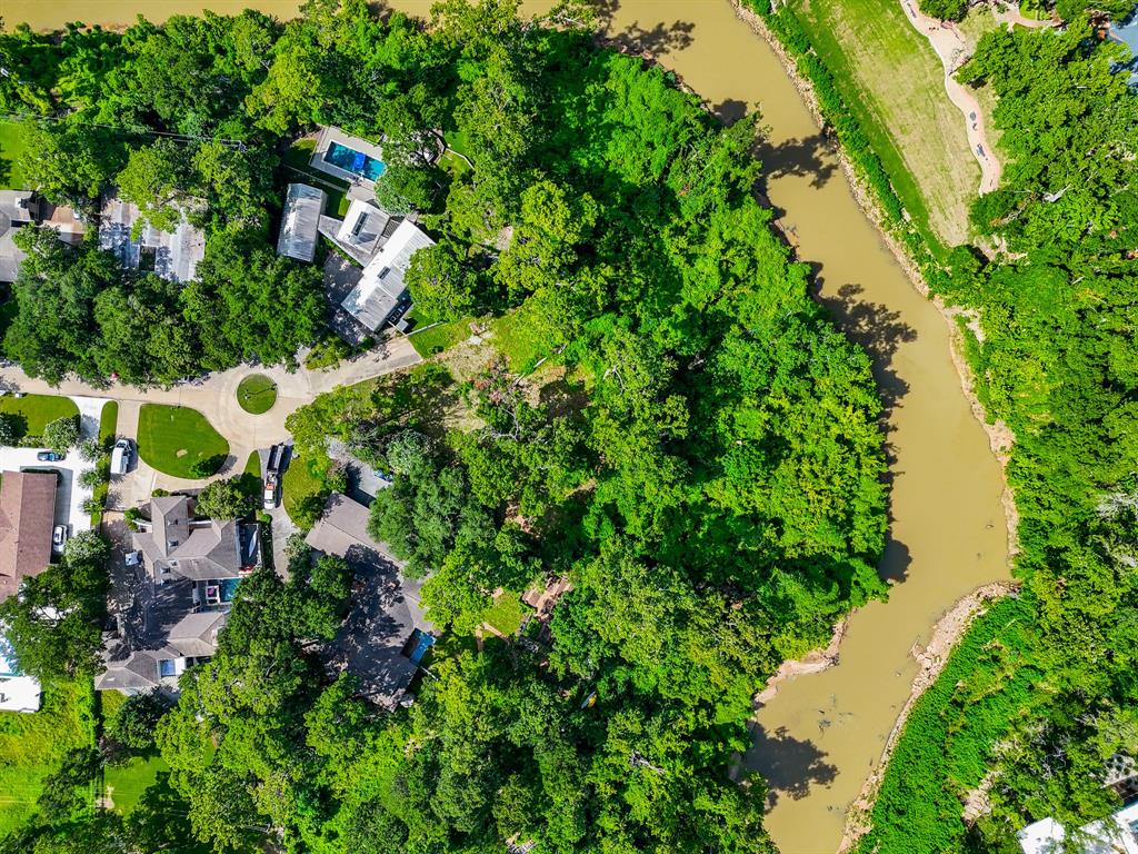 an aerial view of residential house with outdoor space and trees all around