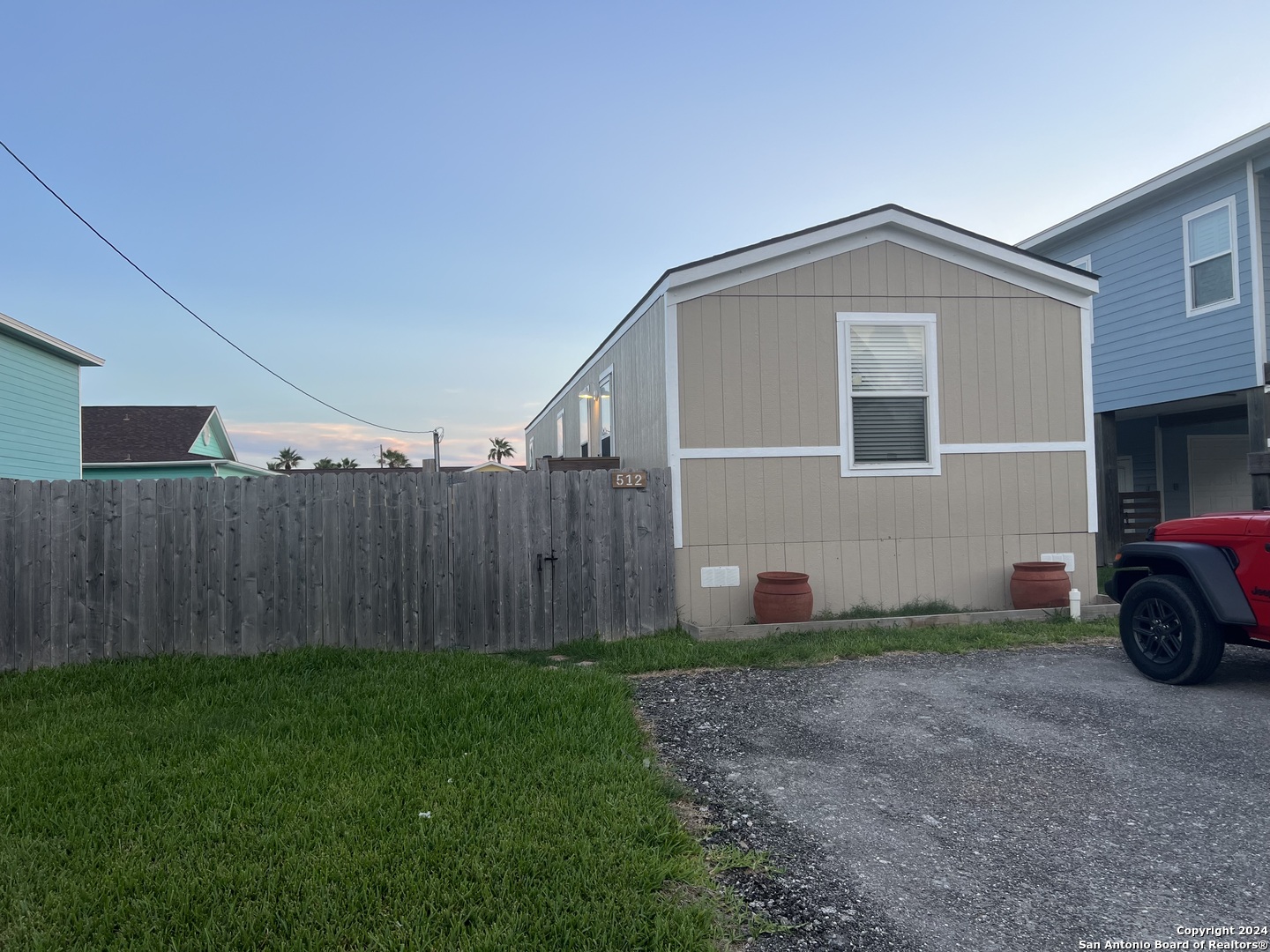 a view of a house with a yard and wooden fence