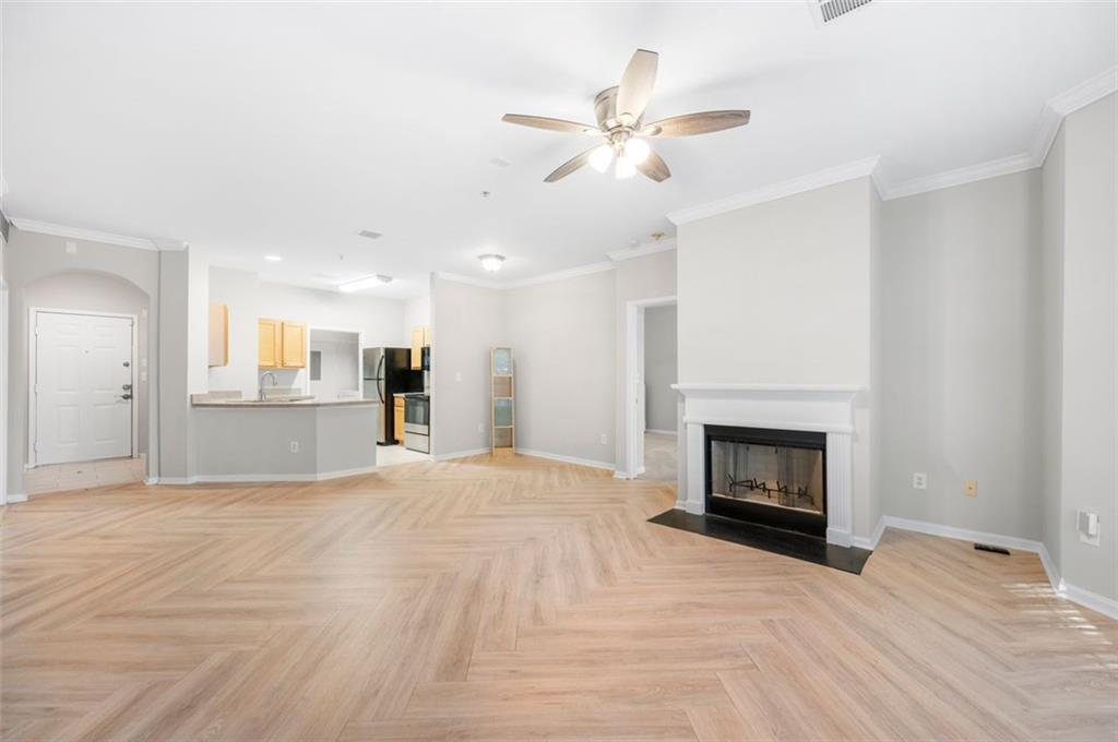 a view of empty room with a fireplace and wooden floor