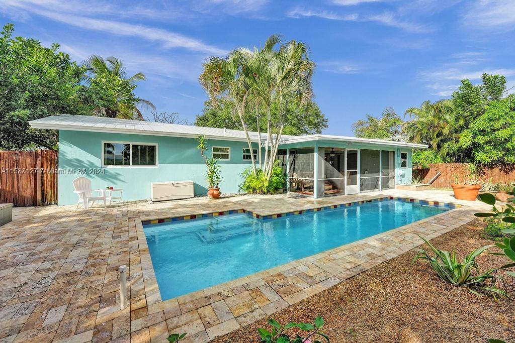 a view of a house with pool fire pit a patio and a yard