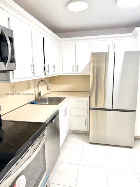 a kitchen with a refrigerator sink and white cabinets