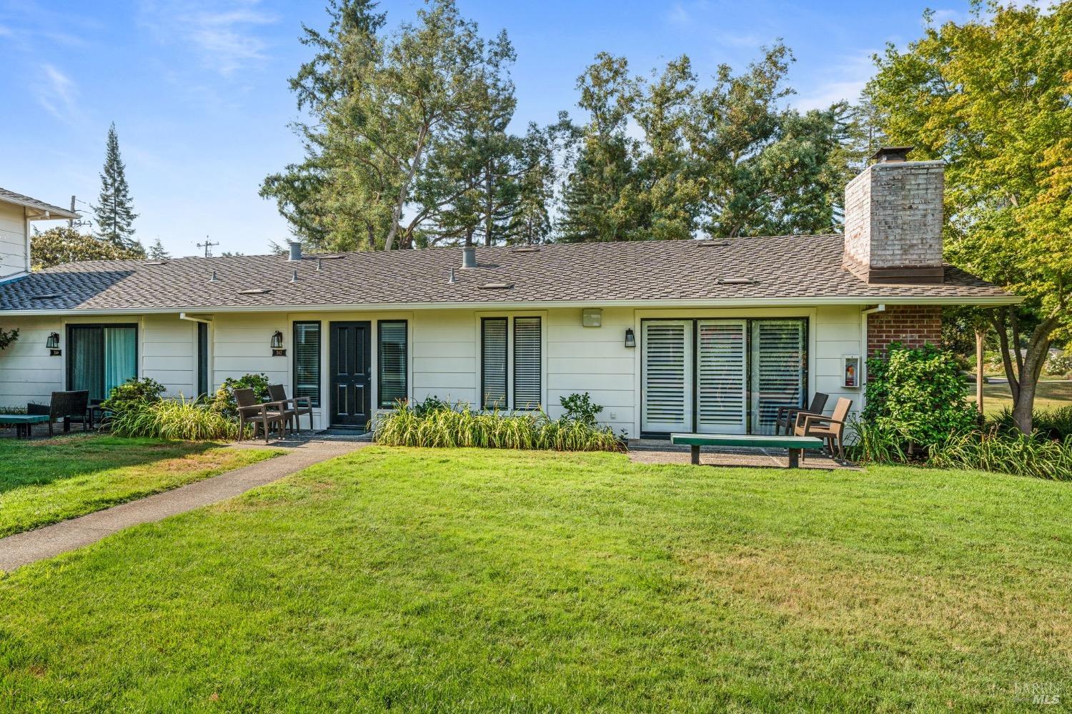 a front view of a house with a yard and trees