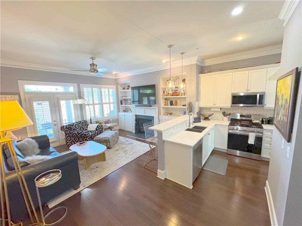 a living room with kitchen island furniture and a flat screen tv