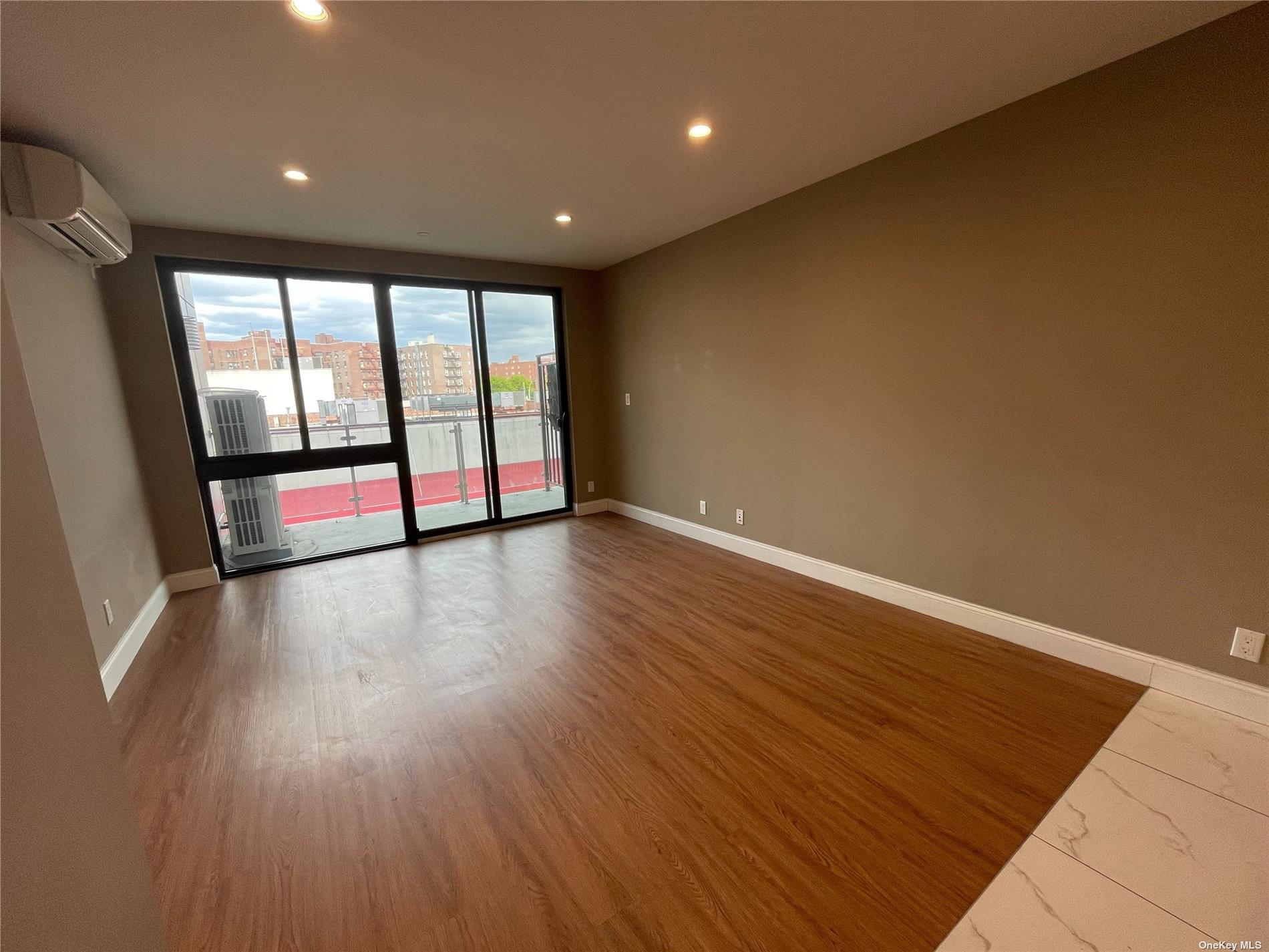 Spare room featuring a wall unit AC and dark hardwood / wood-style floors