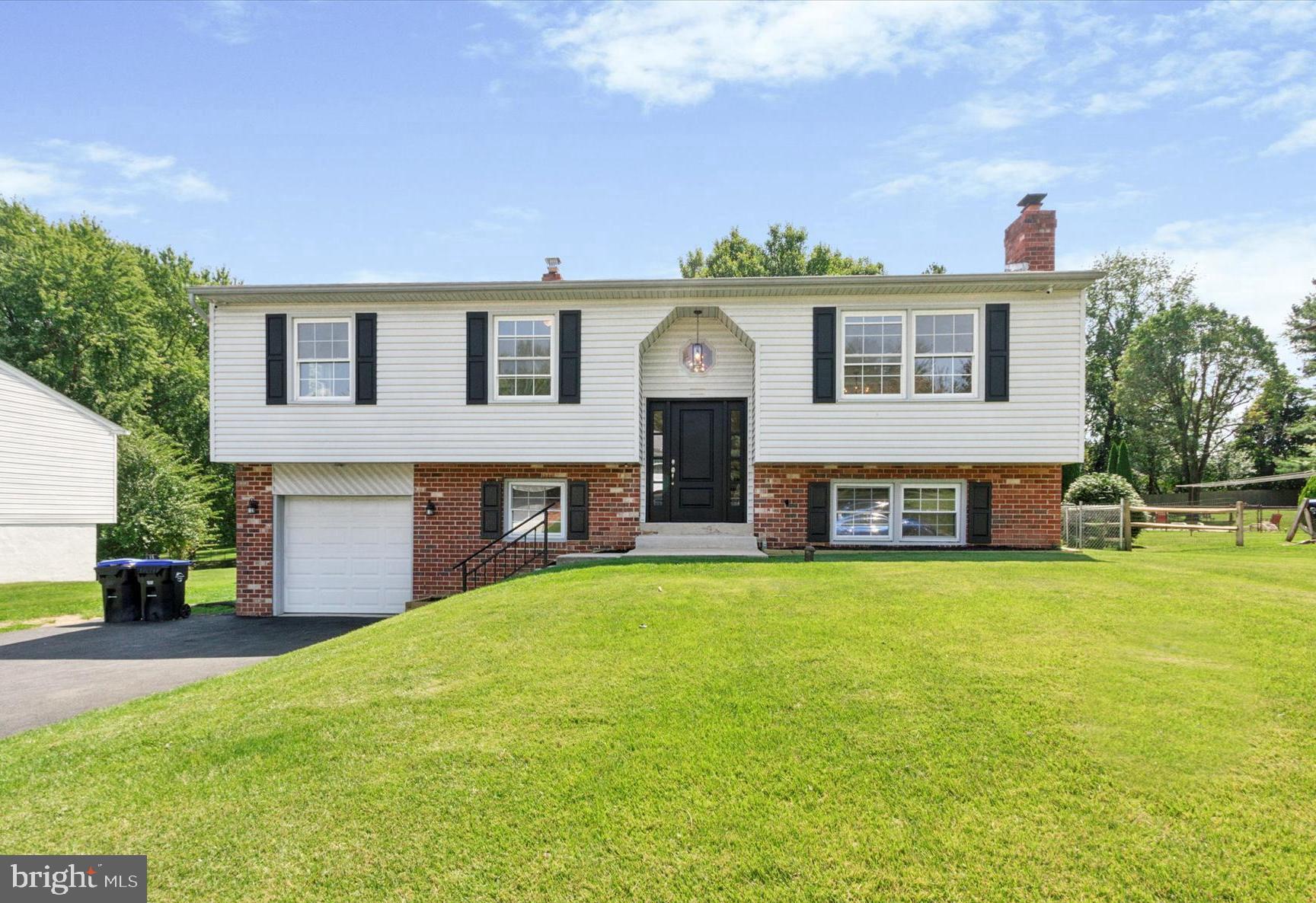 a view of a house with a yard and a garage