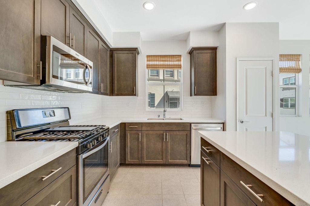 a kitchen with stainless steel appliances a sink stove and cabinets