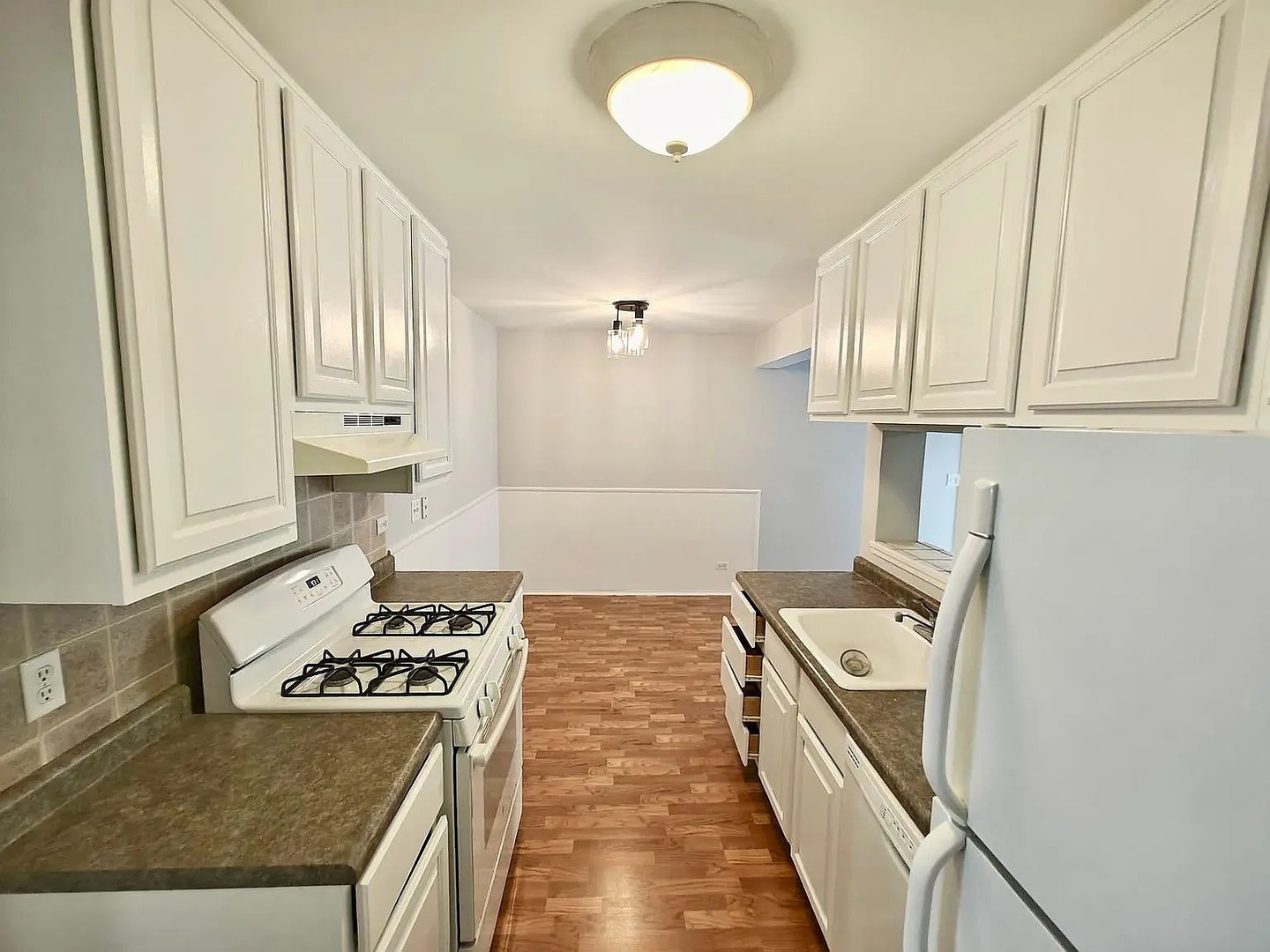 a kitchen with kitchen island a stove a sink and a refrigerator