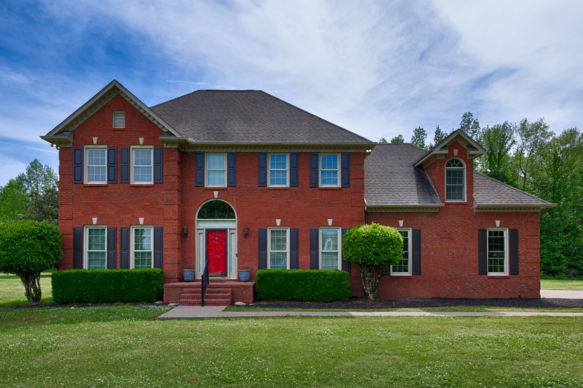 front view of brick house with a yard