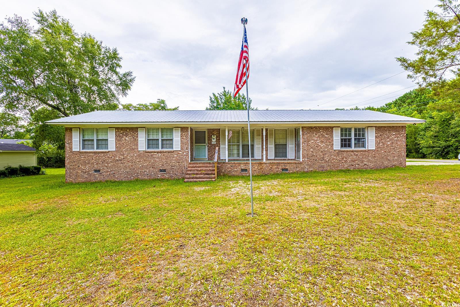 Single story home featuring a porch and a front ya