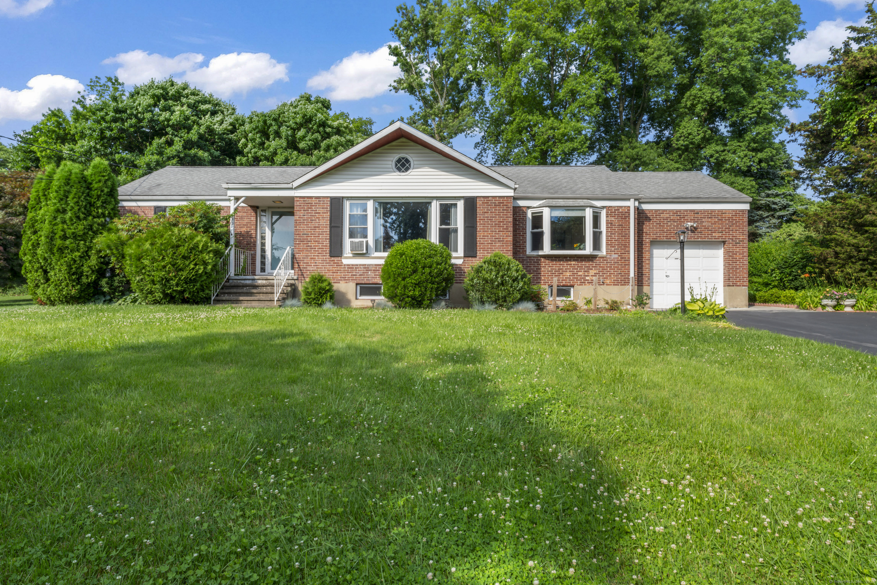 a front view of a house with a yard and green space