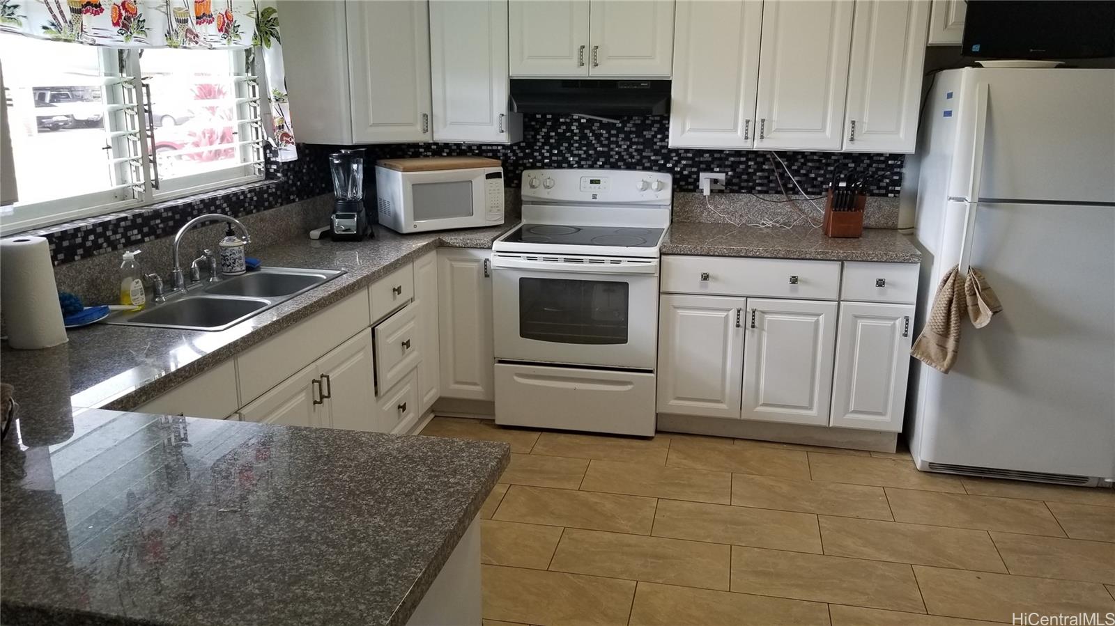 a kitchen with a sink a stove and cabinets