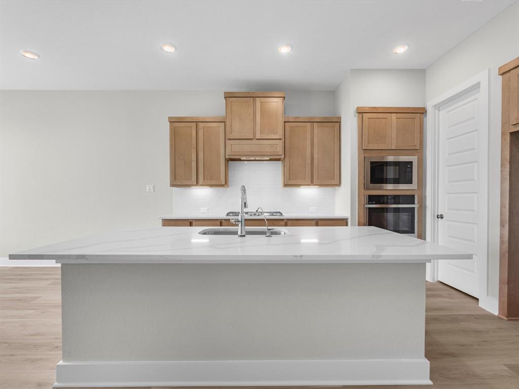 a view of kitchen with stainless steel appliances granite countertop cabinets and wooden floor