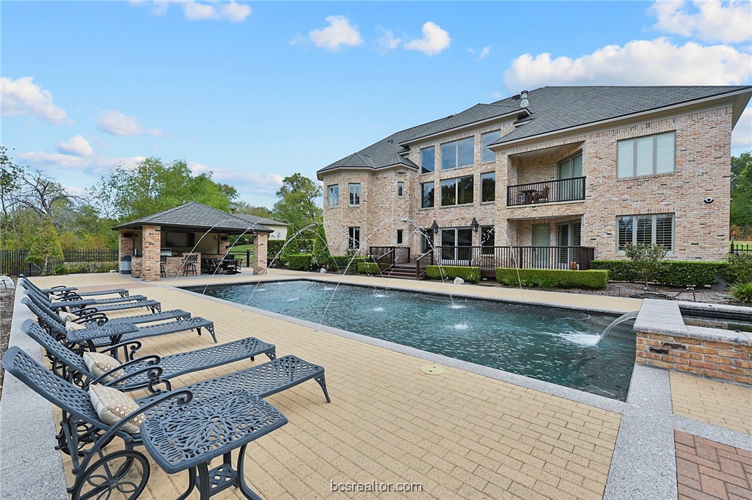 a view of a house with pool and chairs