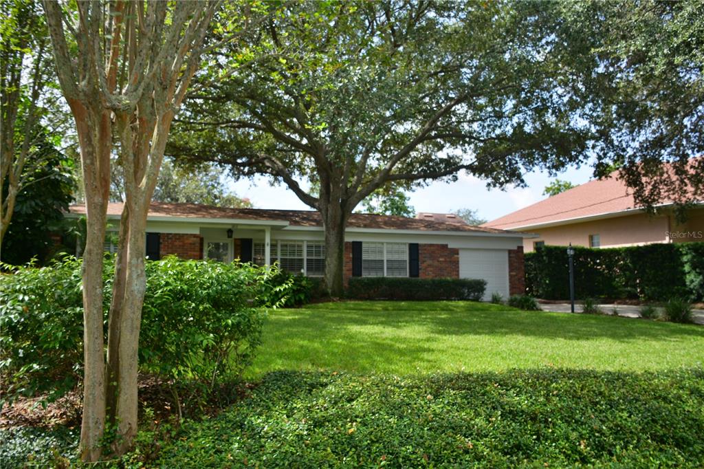 a backyard of a house with large trees and brick walls