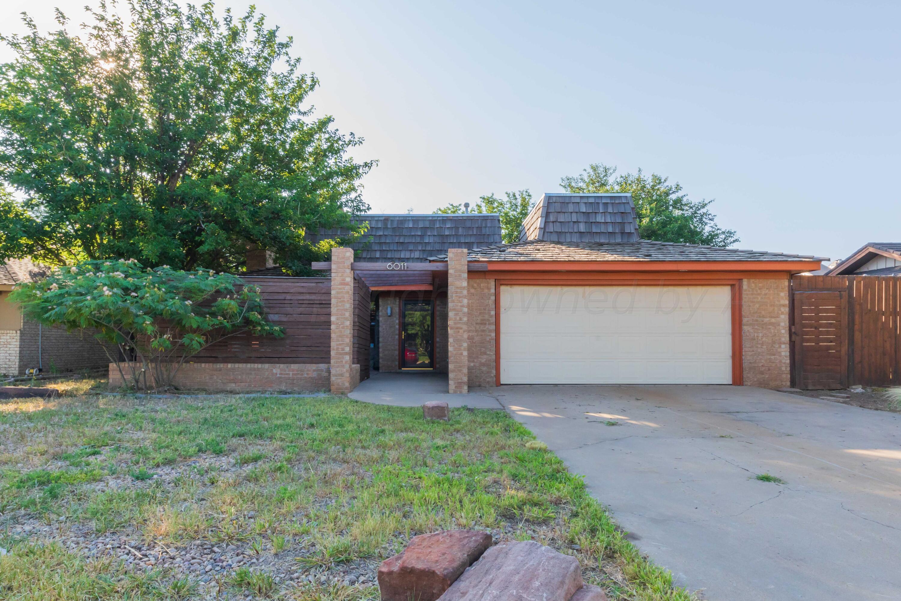 a view of an house with backyard and a garden