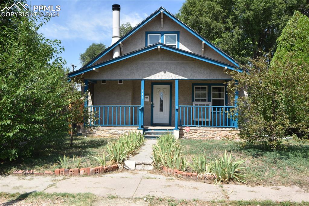 a front view of a house with a yard and trees