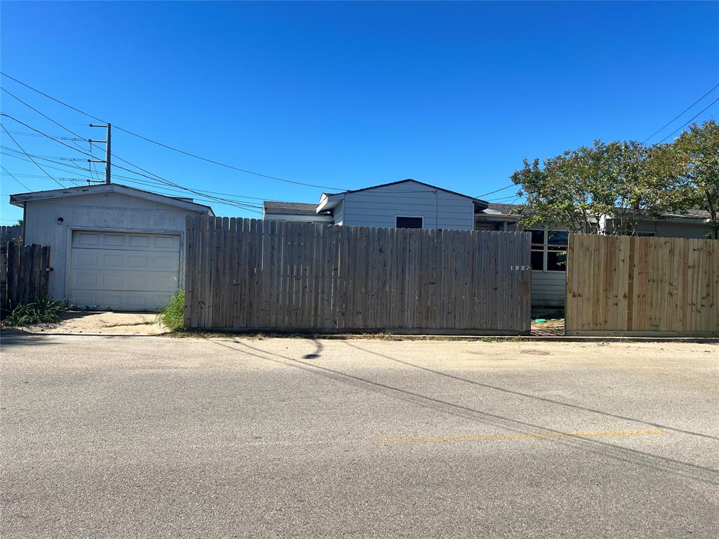 a wooden house with a yard and a wooden fence