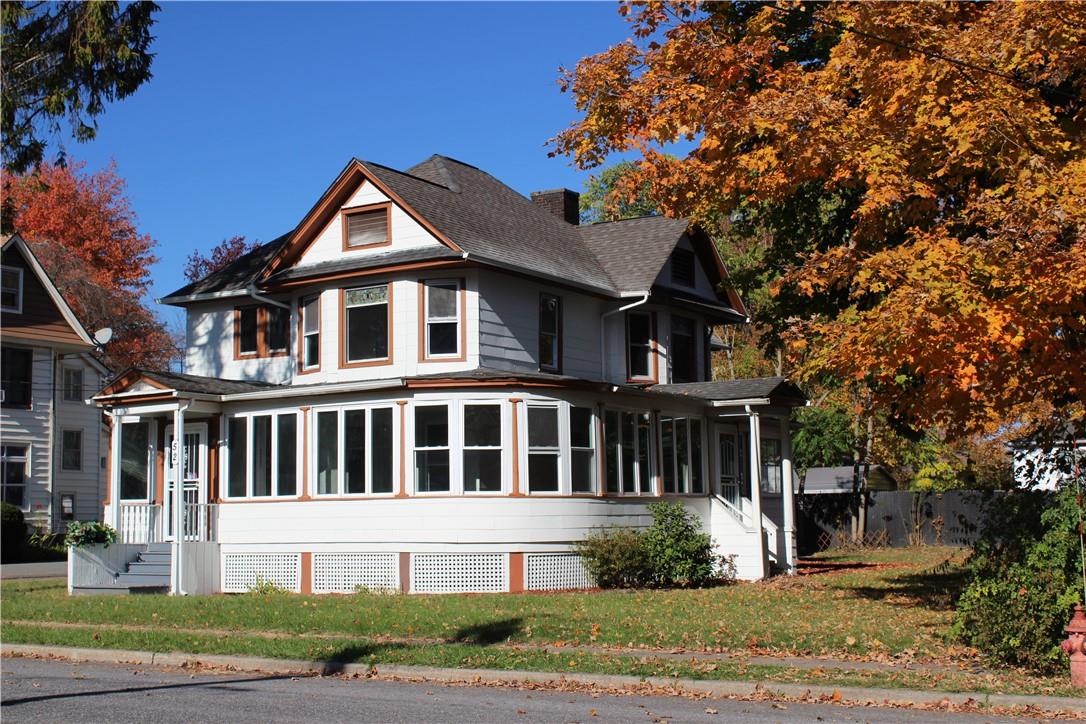 Victorian house featuring a front lawn and a sunroom