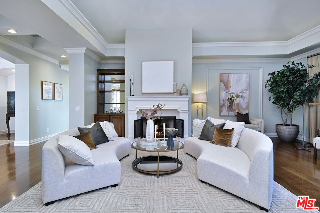 a living room with furniture a fireplace and a potted plant