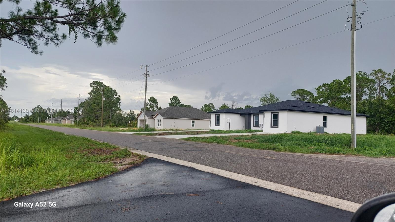 a view of a house with a yard and street