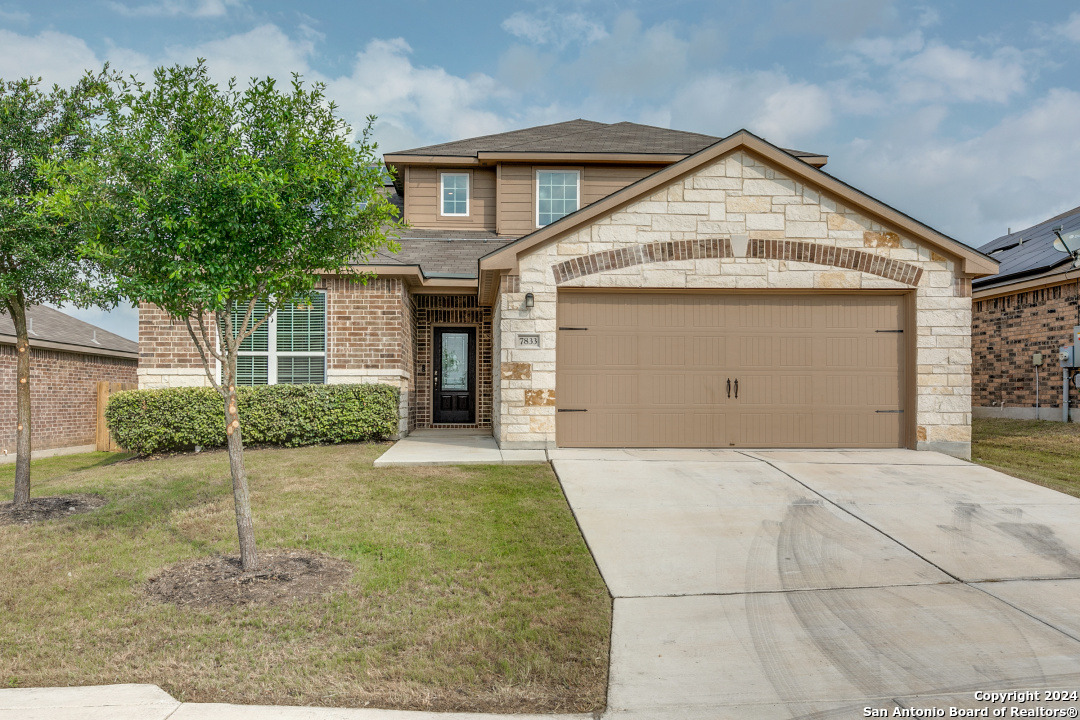 a front view of a house with a yard and garage