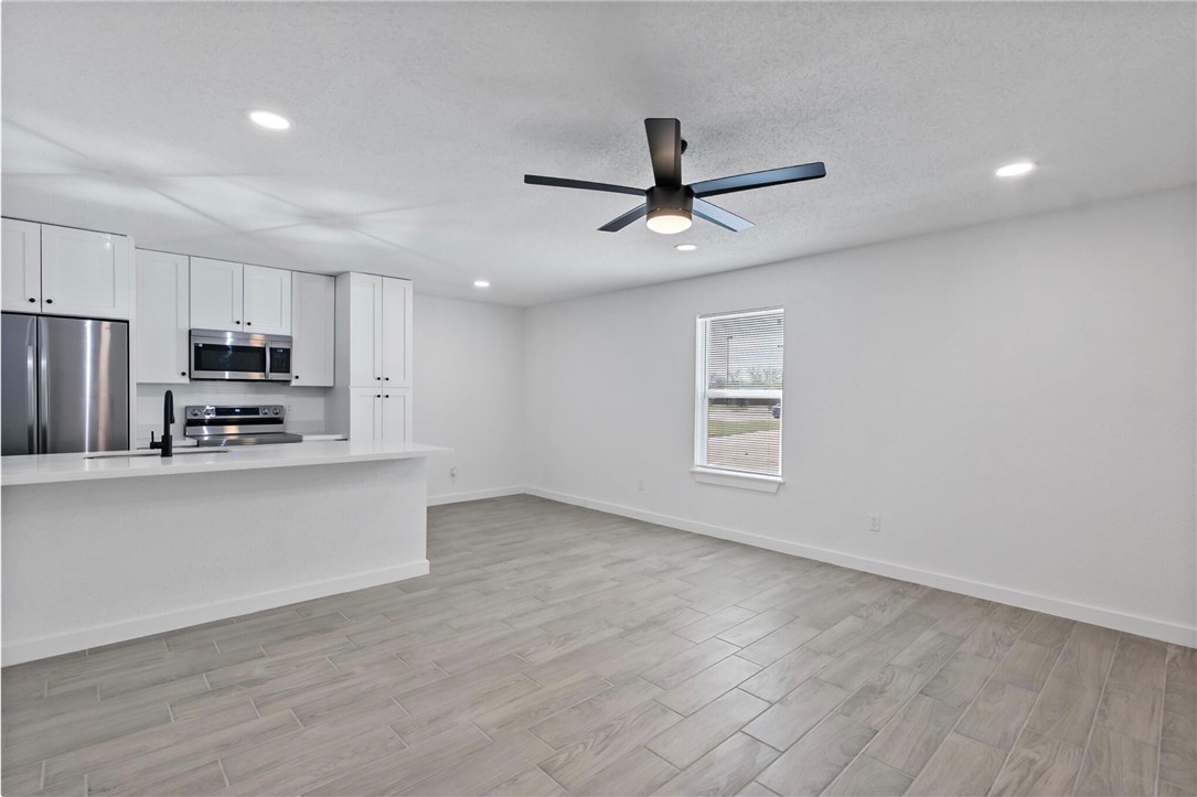 a view of kitchen with stainless steel appliances refrigerator oven and cabinets