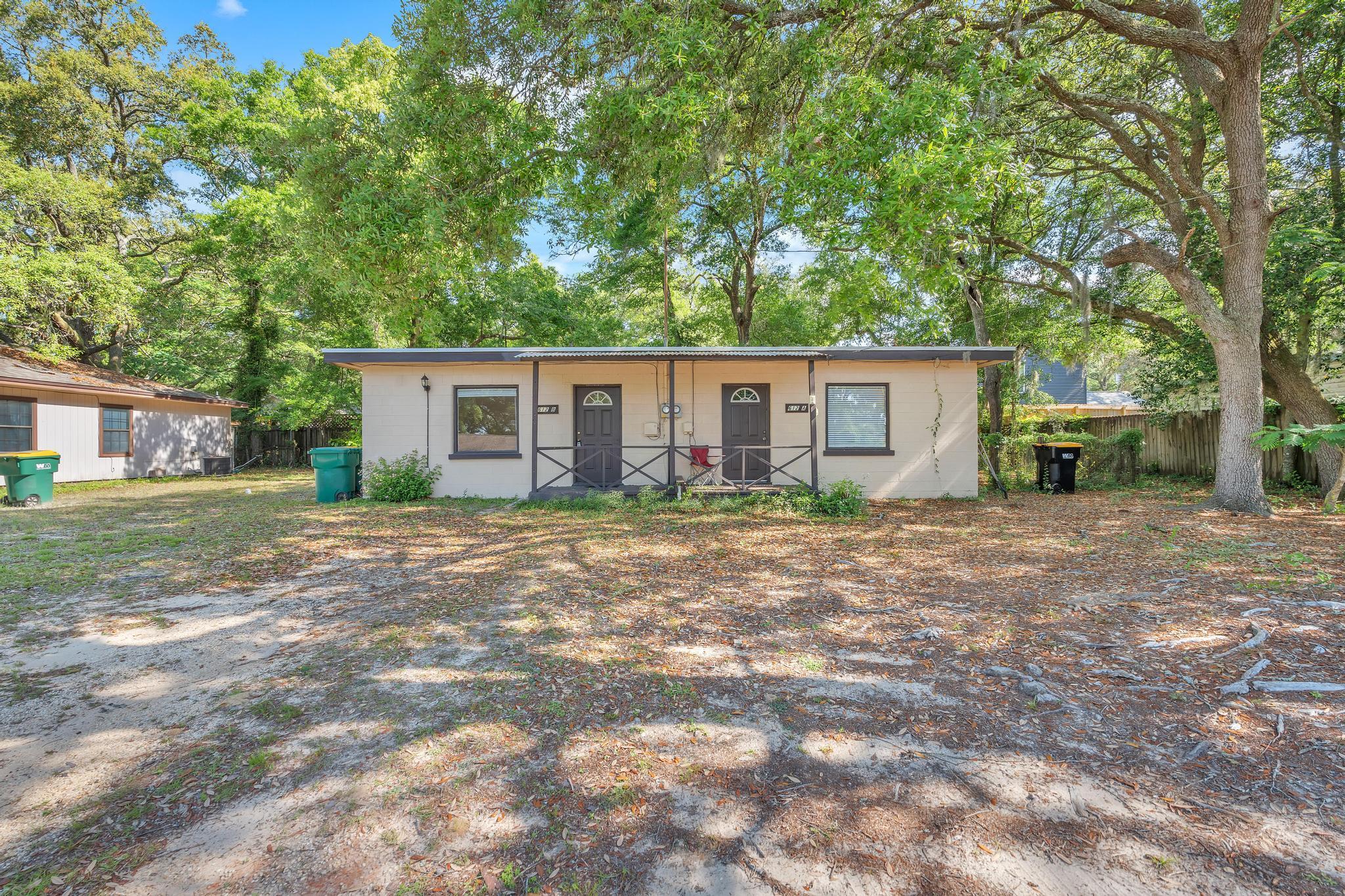 a view of house with backyard and a tree