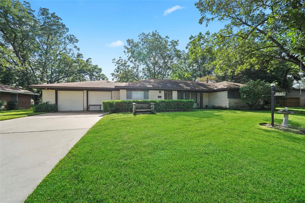 a front view of a house with a yard porch and a tree