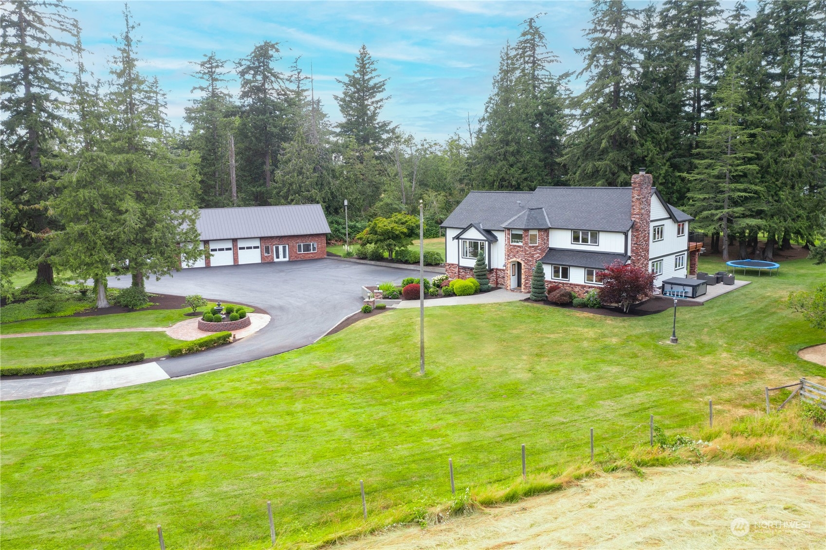 a aerial view of a house with swimming pool garden and trees