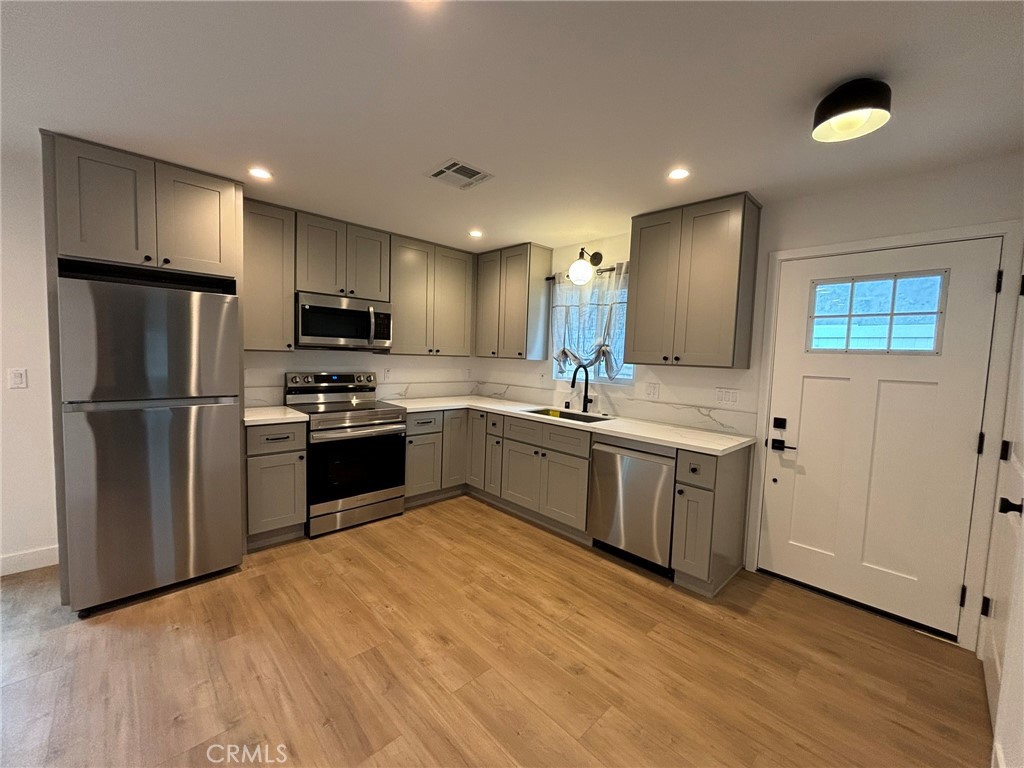 a kitchen with a sink stainless steel appliances and counter space