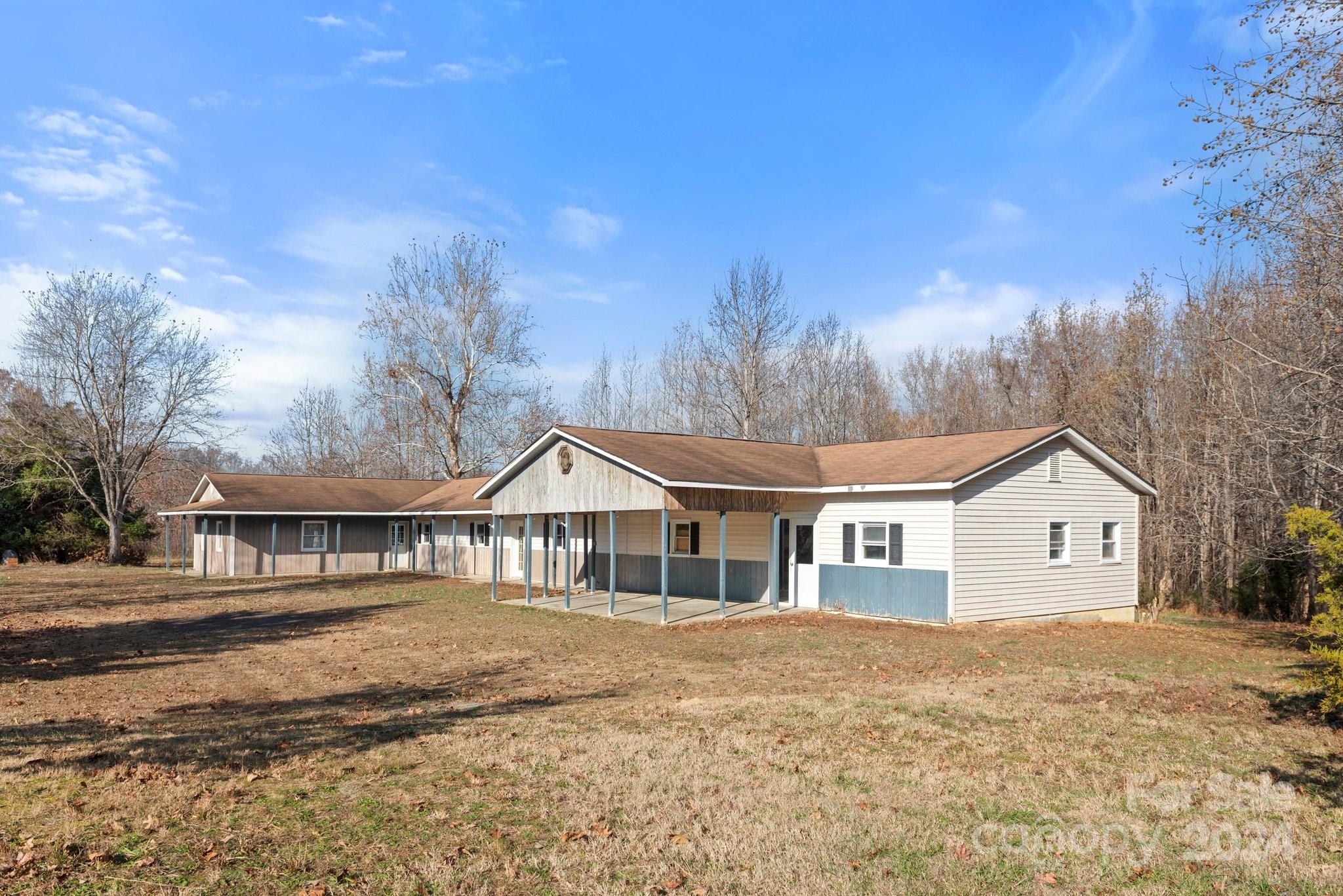 a view of house with yard and sitting area