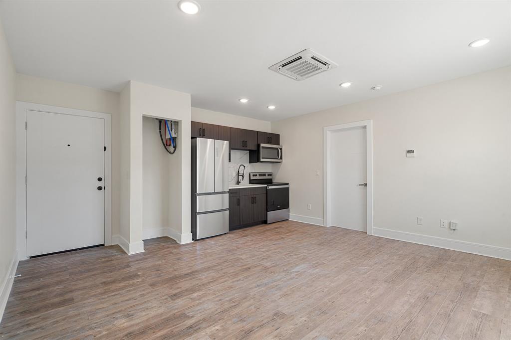 a kitchen with stainless steel appliances kitchen island a refrigerator sink and cabinets