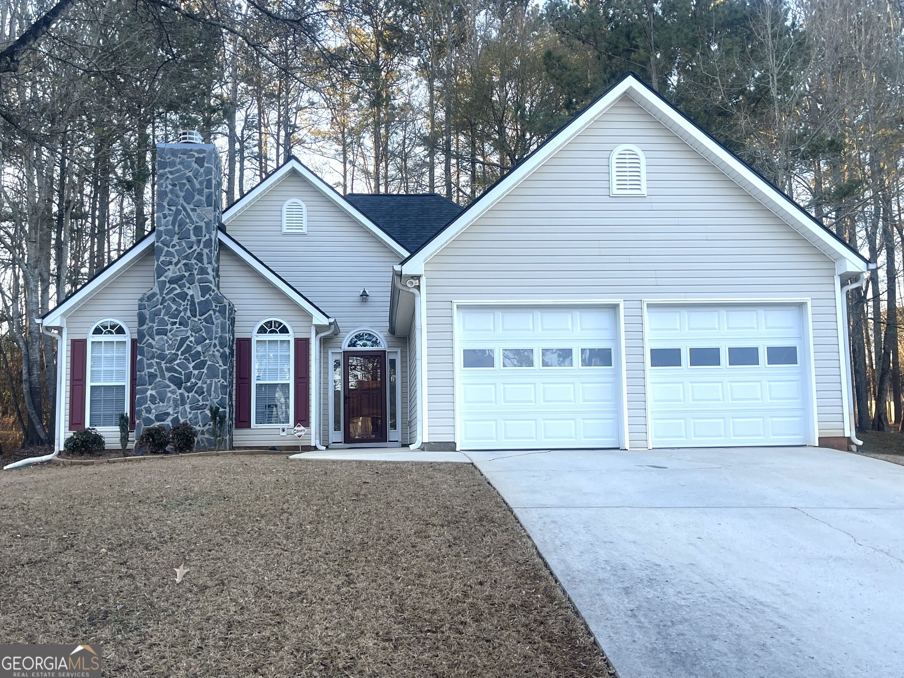 a front view of a house with a garden and trees