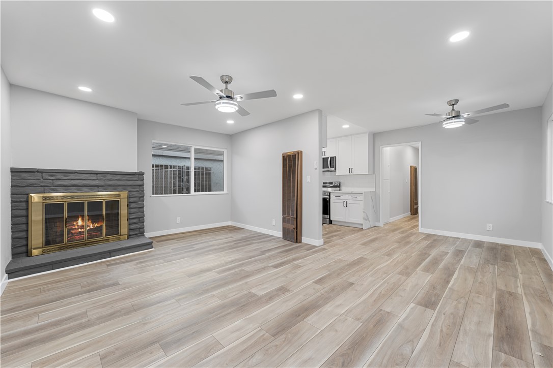 a view of an empty room with a fireplace and a window