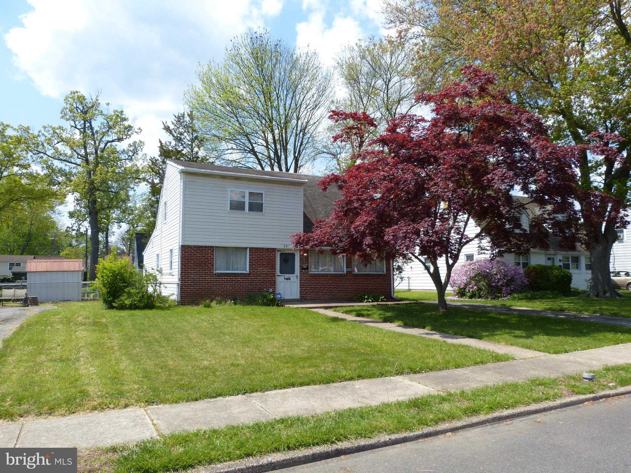 a view of a house with a yard and tree s