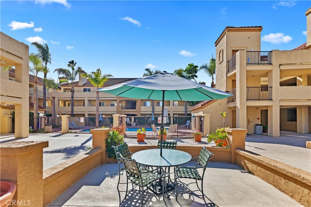 a patio with a table and chairs under an umbrella