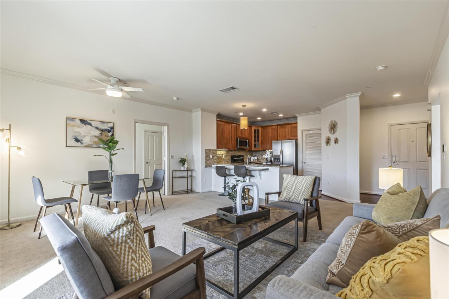 a living room with furniture and a view of kitchen