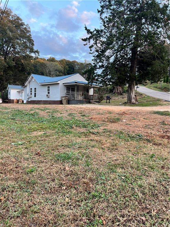 a view of a house with a yard and tree s