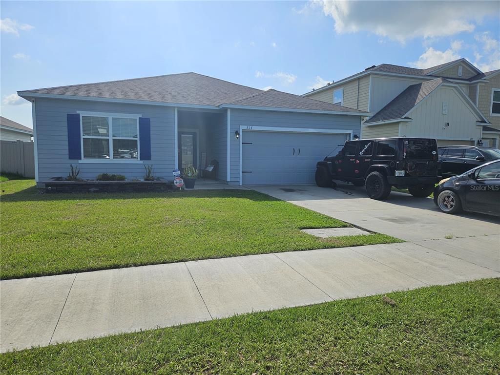 a front view of a house with a garden and yard