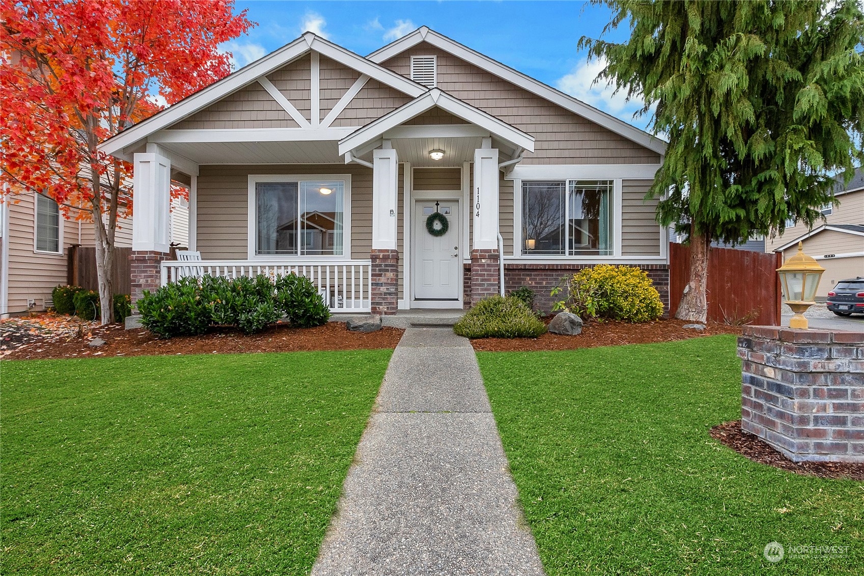 a front view of a house with a yard and potted plants