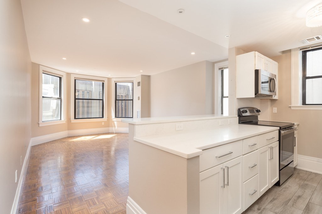 a kitchen with white cabinets and sink