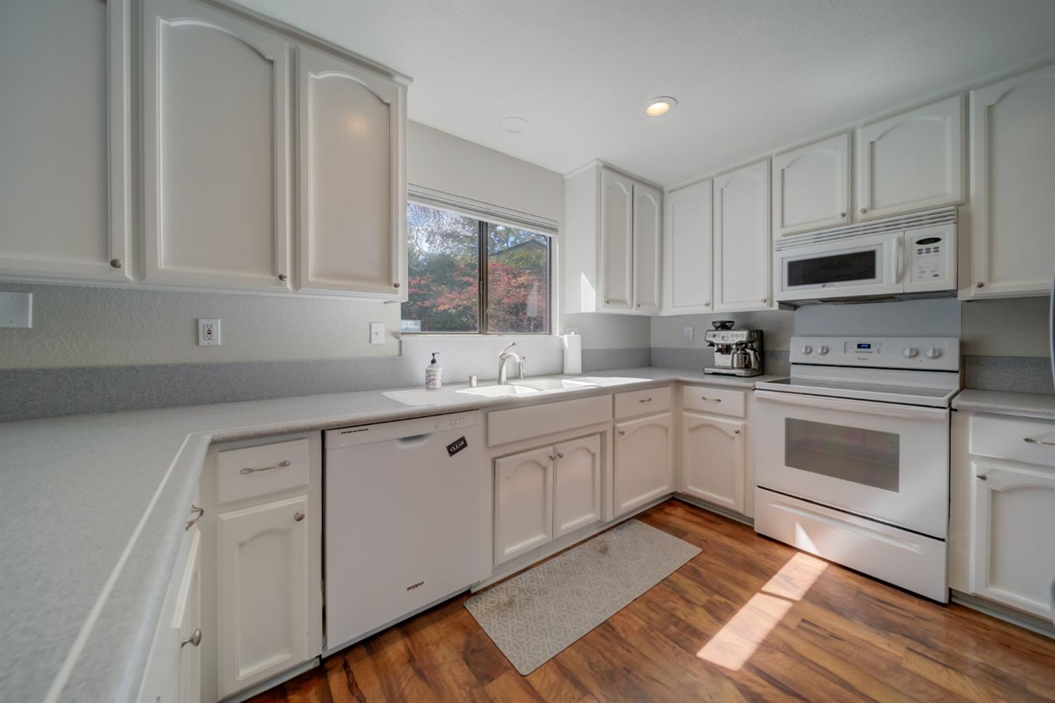 a kitchen with white cabinets white stainless steel appliances and sink