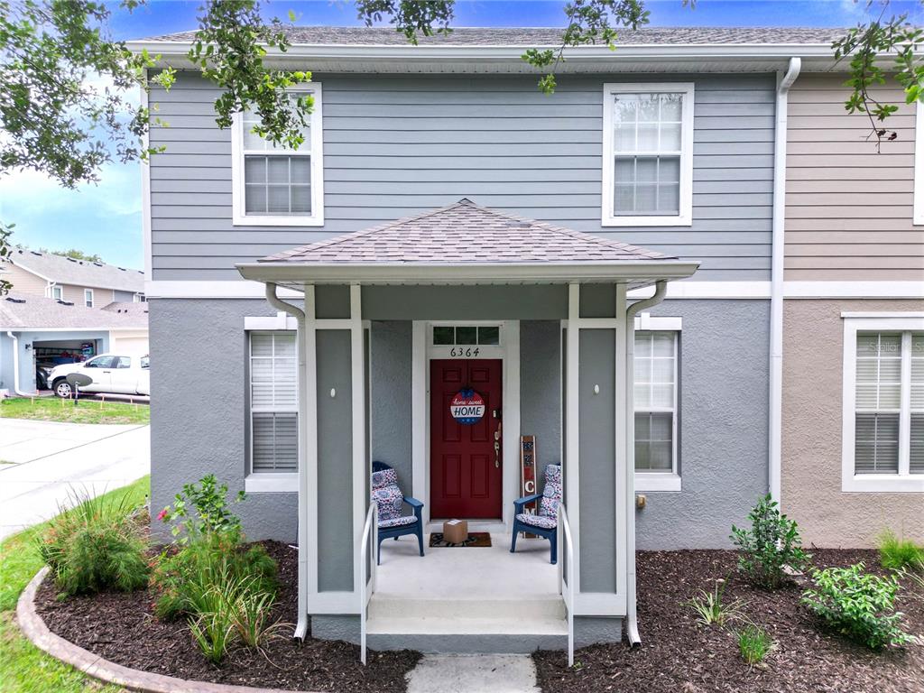 a front view of a house with outdoor seating and a potted plant