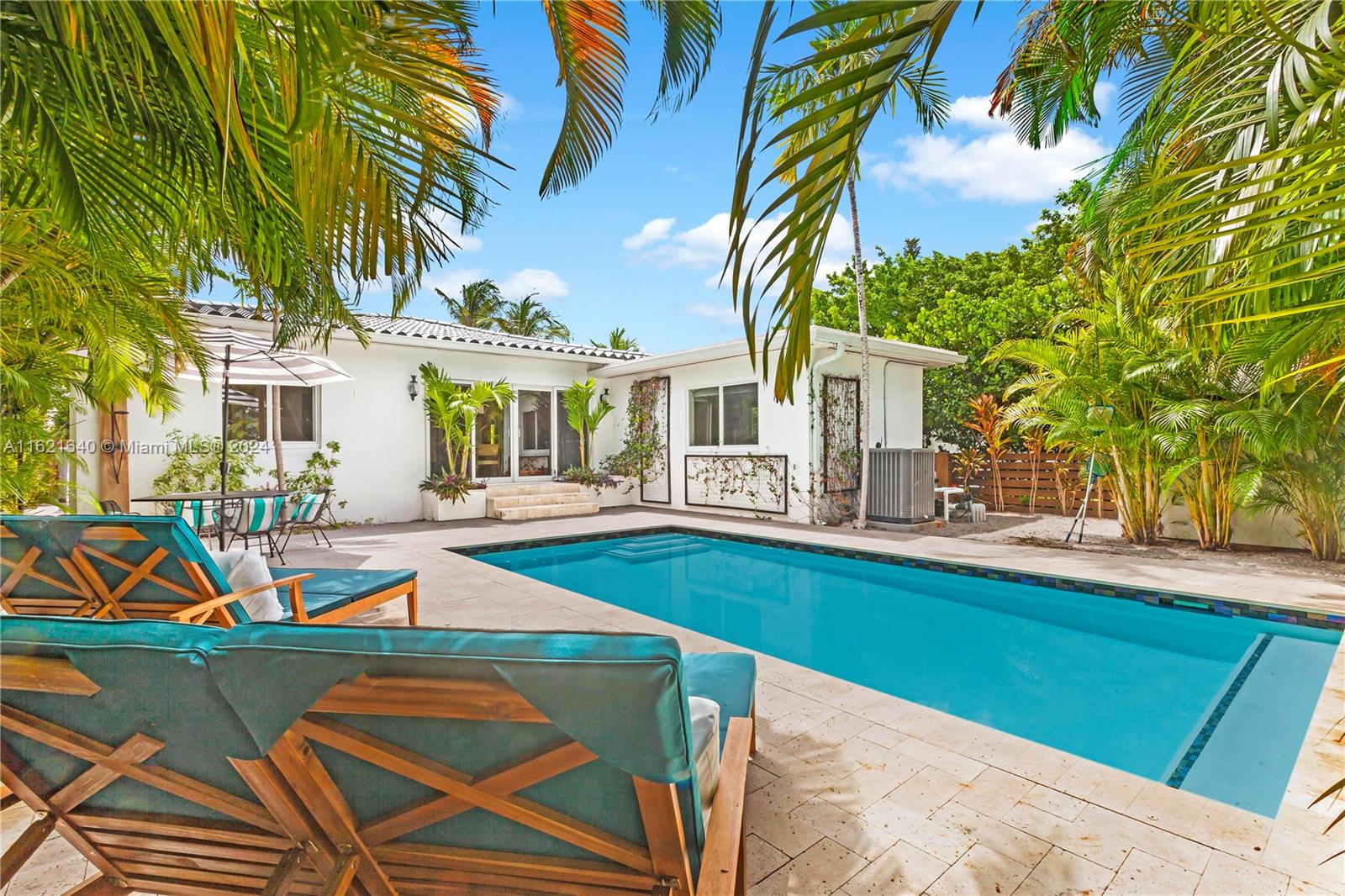 a view of a house with pool and chairs