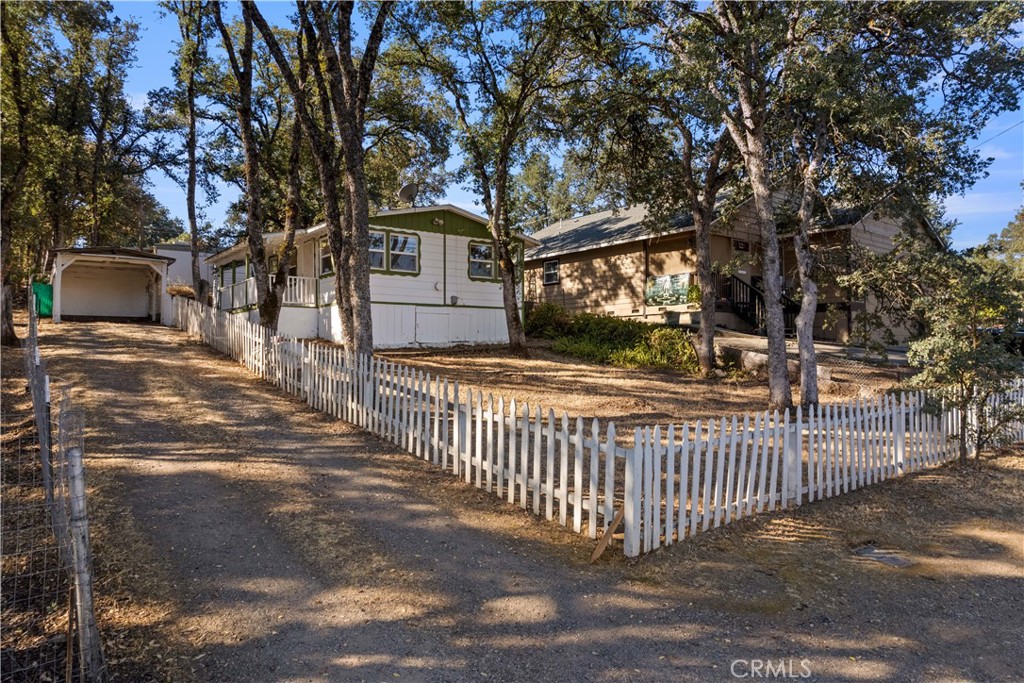 a view of a house with a small yard and wooden fence