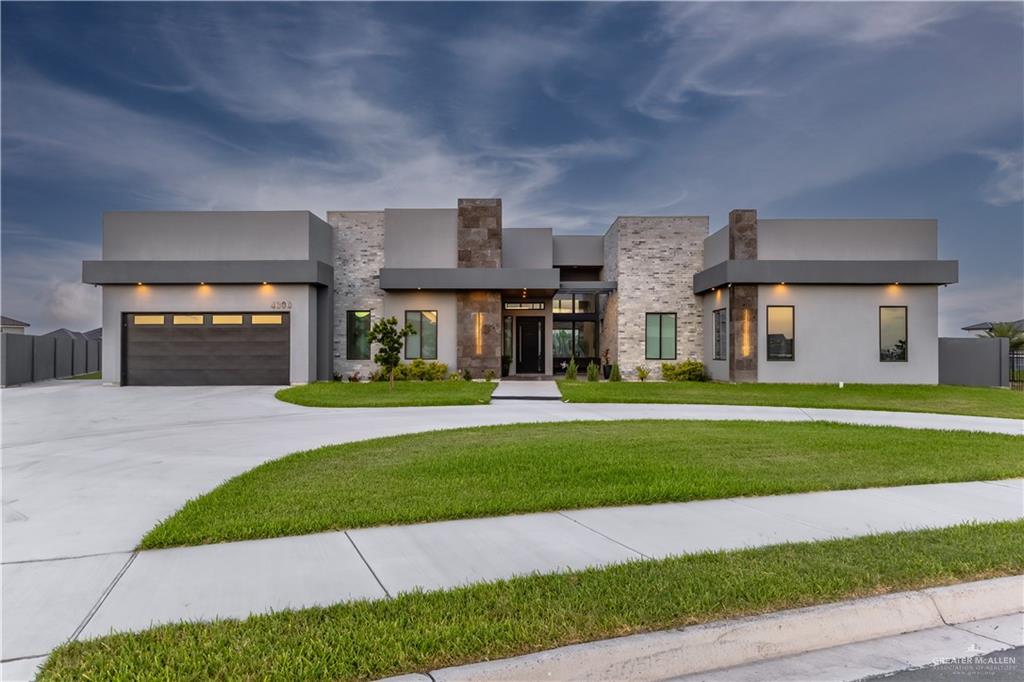 a front view of a house with a yard and a garage