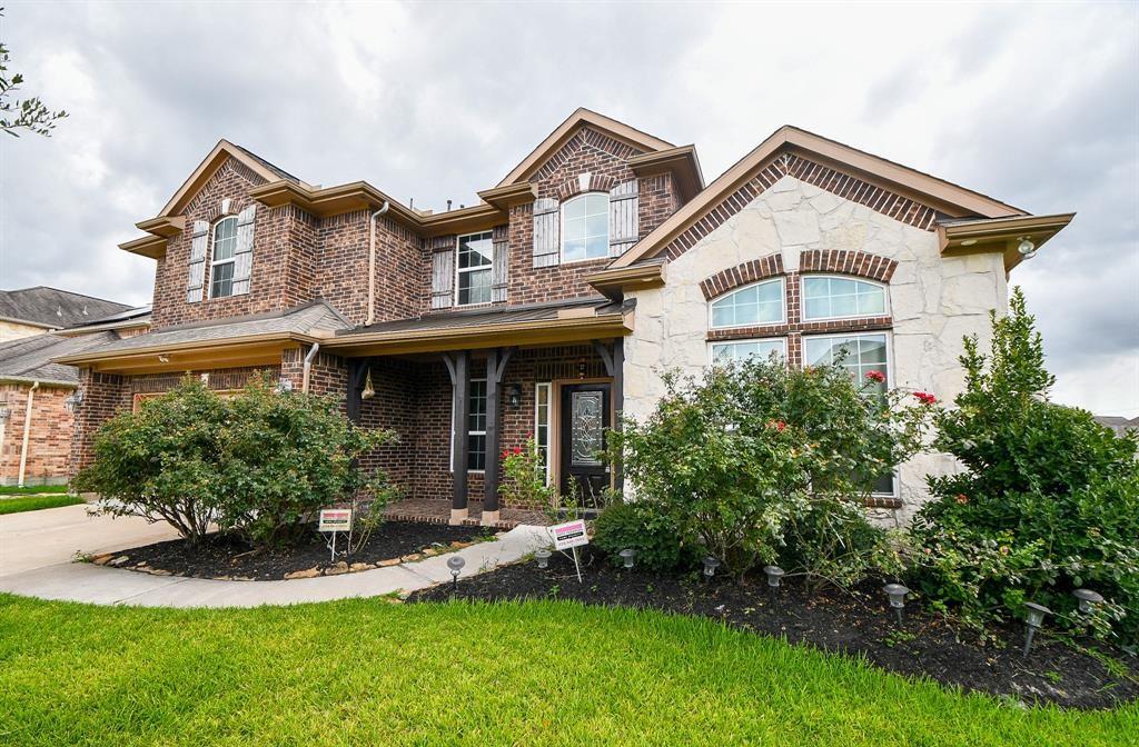 a front view of a house with a yard and green space